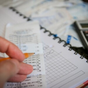 Person figuring out finances with a receipt and calculator