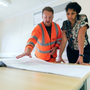 Construction man and woman looking over blueprint plans