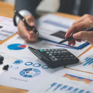 Business men discuss financing over reports and a calculator